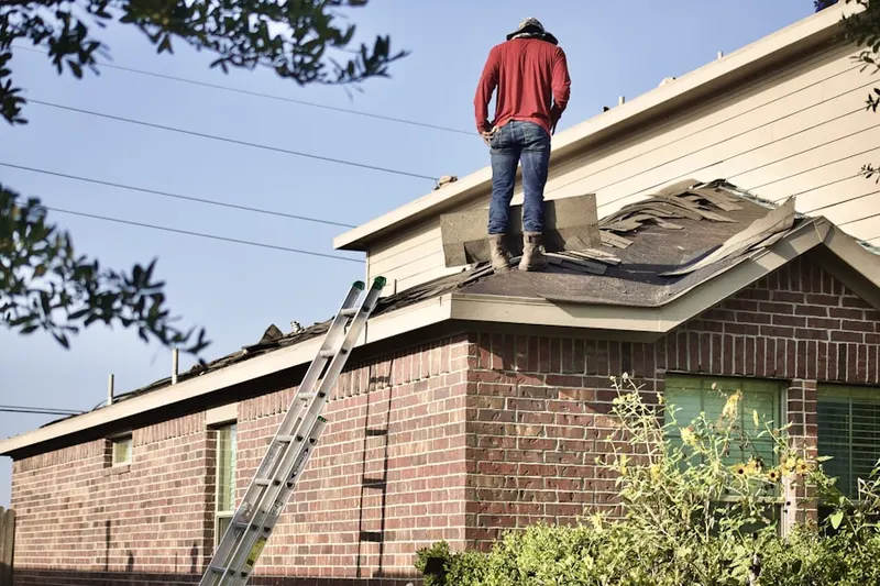 Professional roofer working on a residential roof in Winterset